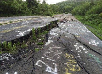 This is the road into Centralia, pictured just last week. It is buckled and broken from the fire which has raged in coal mine shafts under the town for the past 50 years. Tourists have left the graffiti on the road.