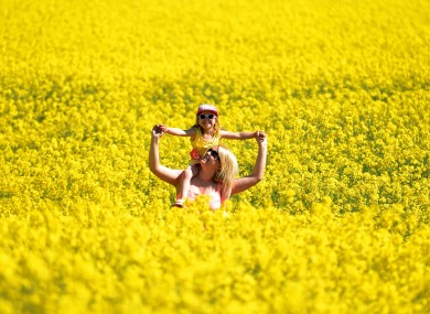 Stephanie Koch and daughter Kadie, 3, enjoy as walk through a rapeseed field in Whitley Bay in England today.