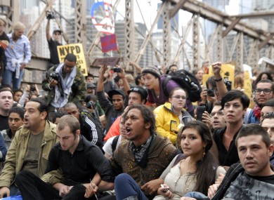 Protesters sit with arms linked on New York's Brooklyn Bridge before police began making arrests during a march by Occupy Wall Street on 1 October 2011