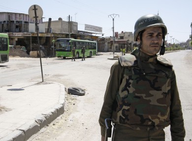 A Syrian government soldier stands guard in Damascus last month