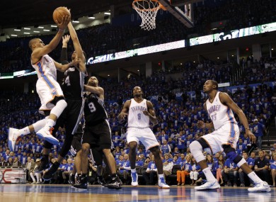 Oklahoma City Thunder point guard Russell Westbrook, left, shoots against San Antonio Spurs guard Danny Green (4) and guard Tony Parker (9).