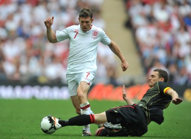 Belgium's Thomas Vermaelen (right) slides in to challenge England's James Milner.