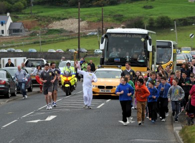 Olympic torchbearer 100 Ciaran Kinney carries the Olympic Flame on the Torch Relay leg between Ballygalley and Glenariff in the North today.