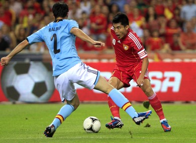 Spain's Raul Albiol, left and China's Zheng Zhi-Cap, right, fight for the ball.
