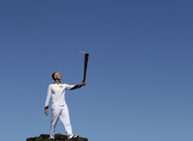 Peter Jack holds the Olympic torch aloft at the Giant's Causeway in county Antrim on Monday.