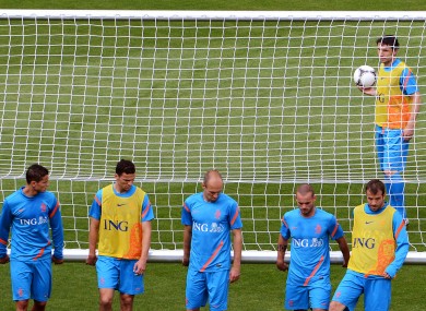 Mark van Bommel looks on as his Dutch teammates move the posts to the other side of the pitch to avoid chanting.