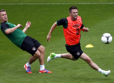 Ireland's Simon Cox, left, and Robbie Keane, right, go for a ball during a training session yesterday.