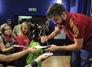 Gerard Pique signs autographs at the Spanish team's base.