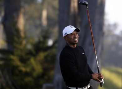 iger Woods watches a shot on the ninth hole during a practice round yesterday.