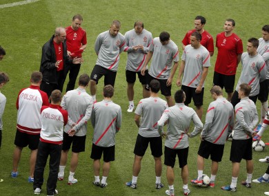 Poland head coach Franciszek Smuda, top left, talks to his players during the official training session yesterday.
