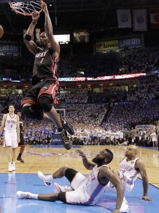 Chris Bosh dunks. hunder guard James Harden (13) and point guard Derek Fisher (37) watch from the floor.