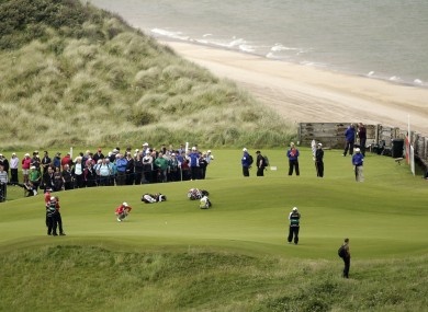 Rory McIlroy, center left, lines up a putt on the 5th green.