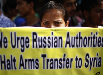 A Nepalese human rights activist holds a placard during a protest rally against the human rights violation in Syria, organized by the Amnesty International outside the United Nations office in Katmandu today