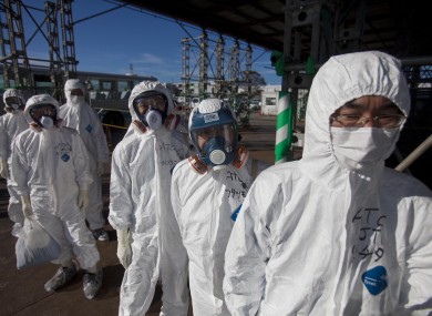 Workers in protective suits and masks wait to enter the emergency operation center at the crippled Fukushima Dai-ichi nuclear power station