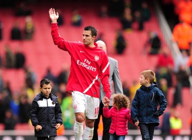Arsenal's Robin van Persie waves to the crowd as he walks around the pitch with his children after Arsenal's last home game of the season.
