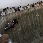 Mohammed Iqbal, 41, rides his motorcycle around a circular vertical track in an entertainment park in Islamabad, Pakistan. (AP Photo/Muhammed Muheisen)