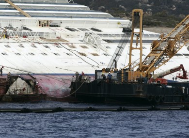 Workers begin to remove the tons of rocky reef embedded into the Costa Concordia cruise ship's hull earlier this month.