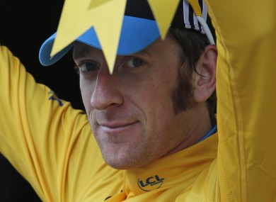 Bradley Wiggins of Britain, wearing the overall leader's yellow jersey, celebrates on the podium of the 17th stage of the Tour de France.