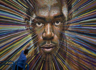 Australian street artist James Cochran spray paints a portrait of Usain Bolt, Jamaica's world record holder in the 100 and 200 meter sprints, on the wall of a building beside a car park in east London.
