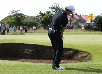 Rory McIlroy chips over a bumker onto the 2nd green.