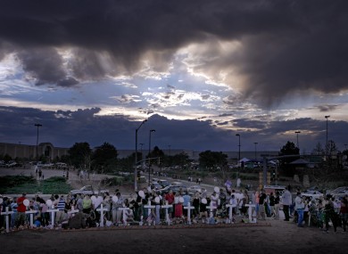 Storm clouds gather above a memorial for the victims in the shooting across the street from the Century 16 movie theatre.