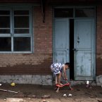 A child plays on the muds outside his flood-hit home at a village in Fangshan district of Beijing (AP Photo/Andy Wong)