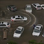 Vehicles are submerged at a flooded residence community (Photo by ChinaFotoPress)