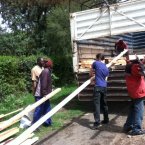 James Hennessy (centre) and colleagues transporting materials for their greenhouse to the farm
