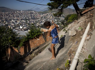 A girl sweeps up in the Chatuba slum, inside the Penha complex, in Rio de Janeiro.