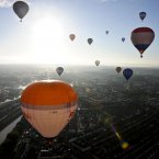 A hot air balloons fly over Bristol on a sunny summer morning on the week that will see the 34th Bristol International Balloon Fiesta take place at Ashton Court Estate as balloonists from all over the world gather at what is the largest balloon event in Europe. Photo: Ben Birchall/PA Wire