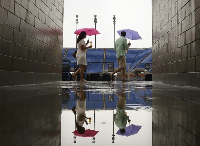 Rain, rain, go away: Spectators try to stay dry on Monday at Flushing Meadows.