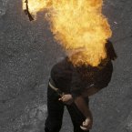 A protester throws a fire bomb toward the riot police during clashes in Athens, Wednesday Sept. 26, 2012. Police clashed with protesters hurling petrol bombs and bottles after an anti-government rally called as part of a general strike in Greece turned violent. About 50,000 people joined the union-organized march held during a general strike against new austerity measures planned in the crisis-hit country. (AP Photo/Dimitri Messinis)