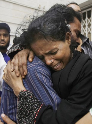 Family members mourn the death of a man outside a mortuary in Karachi, Pakistan, Wednesday, Sept. 12, 2012