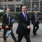 British Prime Minister David Cameron strides into the EU summit in Brussels today. (AP Photo/Yves Logghe)