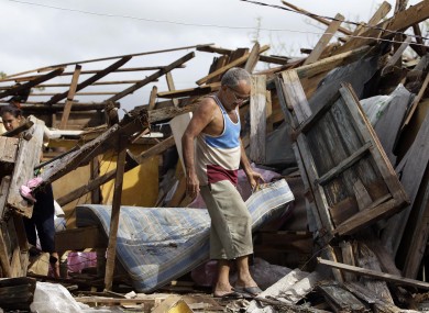 Resident Antonio Garces tries to recover his belongings from his house destroyed by Hurricane Sandy in Aguacate, Cuba, Thursday Oct. 25, 2012