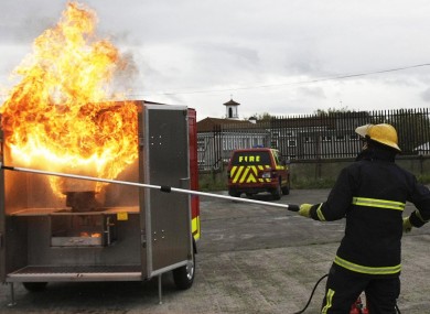 A fire officer demonstrating how not to put out a chip pan fire