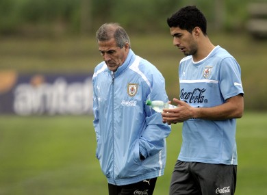 Uruguay coach Oscar Tabarez, left, and striker Luis Suarez walk together on the pitch after a training session on the outskirts of Montevideo yesterday.