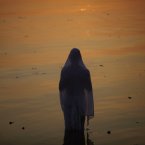 An Indian Hindu devotee performs rituals at sunset during Chhath Puja festival, in the Hussan Sagar Lake (Tankbund) in Hyderabad, India, Monday, Nov. 19, 2012. On Chhath, an ancient Hindu festival, rituals are performed to thank the Sun God for sustaining life on earth. (AP Photo/Mahesh Kumar A.)