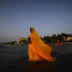 A Hindu devotee offers prayers to the setting sun during Chhath Puha festival, in the Arabian Sea, Mumbai, India, Monday, Nov. 19, 2012. On Chhath, an ancient Hindu festival, rituals are performed to thank the Sun God for sustaining life on earth. (AP Photo/Rafiq Maqbool)