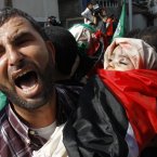 A Palestinian man holds the body of 11-month-old Ibrahim Daloo during a funeral for members of the Daloo family in Gaza City.
(AP Photo/Majed Hadman)