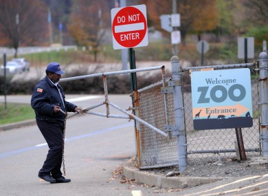 A security guard closes the gate at the Pittsburgh Zoo yesterday