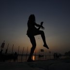A Hindu holy man is silhouetted against the setting sun as he performs yoga at Sangam, the confluence of the Ganges, and Yamuna during the Maha Kumbh Mela, in Allahabad, India. Millions of Hindu pilgrims are expected to attend the Maha Kumbh festival, which is one of the world's largest religious gatherings that lasts 55 days and falls every 12 years. During the festival pilgrims bathe in the holy Ganges River in a ritual they believe can wash away their sins. (AP Photo/ Rajesh Kumar Singh)