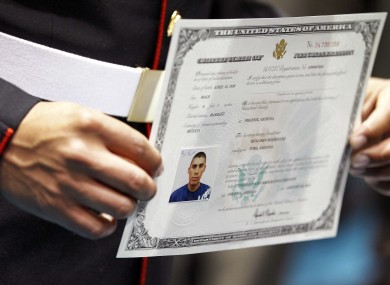 US Marine Lance Crpl. Benjamin Rodriguez displays his certficate of Citizenship after taking the oath of citizenship
