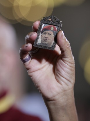 A woman holds up an image of Venezuela's President Hugo Chavez as people gather to pray for him at a church in Caracas, Venezuela.