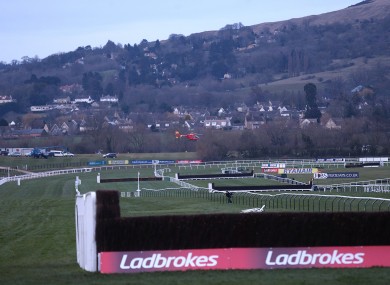 An air ambulance carrying jockey JT McNamara flies over the Cheltenham course.